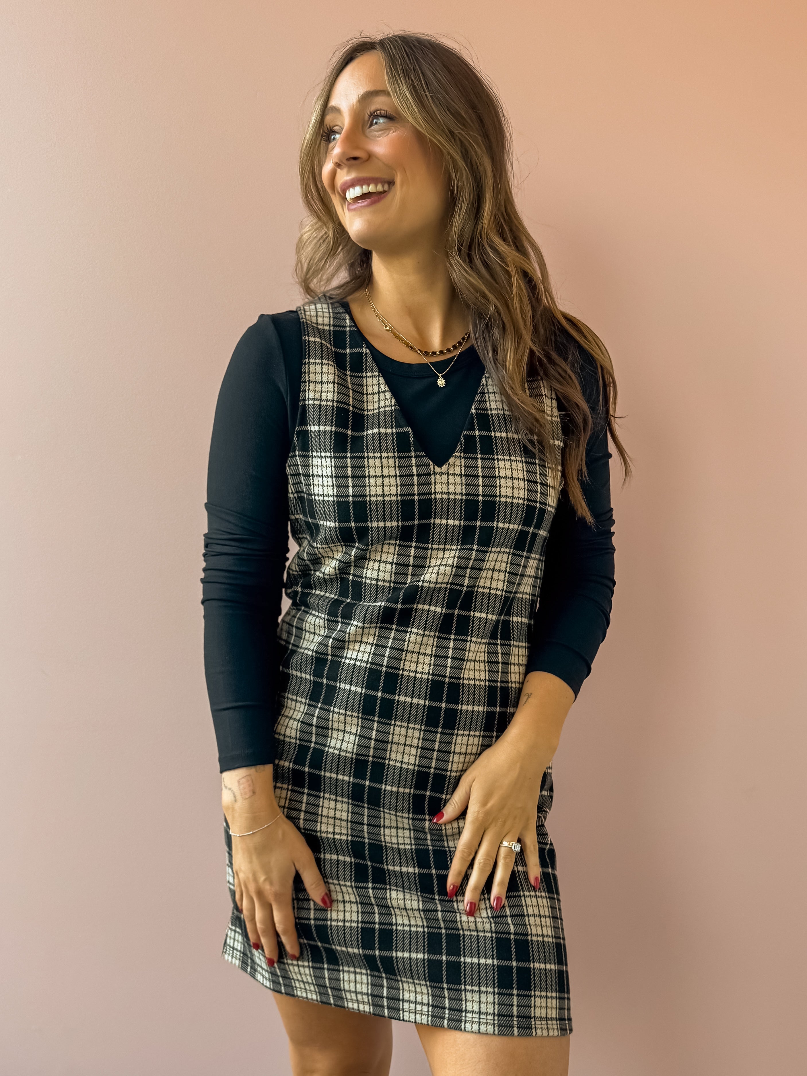 Sadie & Sage Served Up Stretch Plaid Mini Dress in black and tan plaid, front close-up, layered over a black long sleeve top.