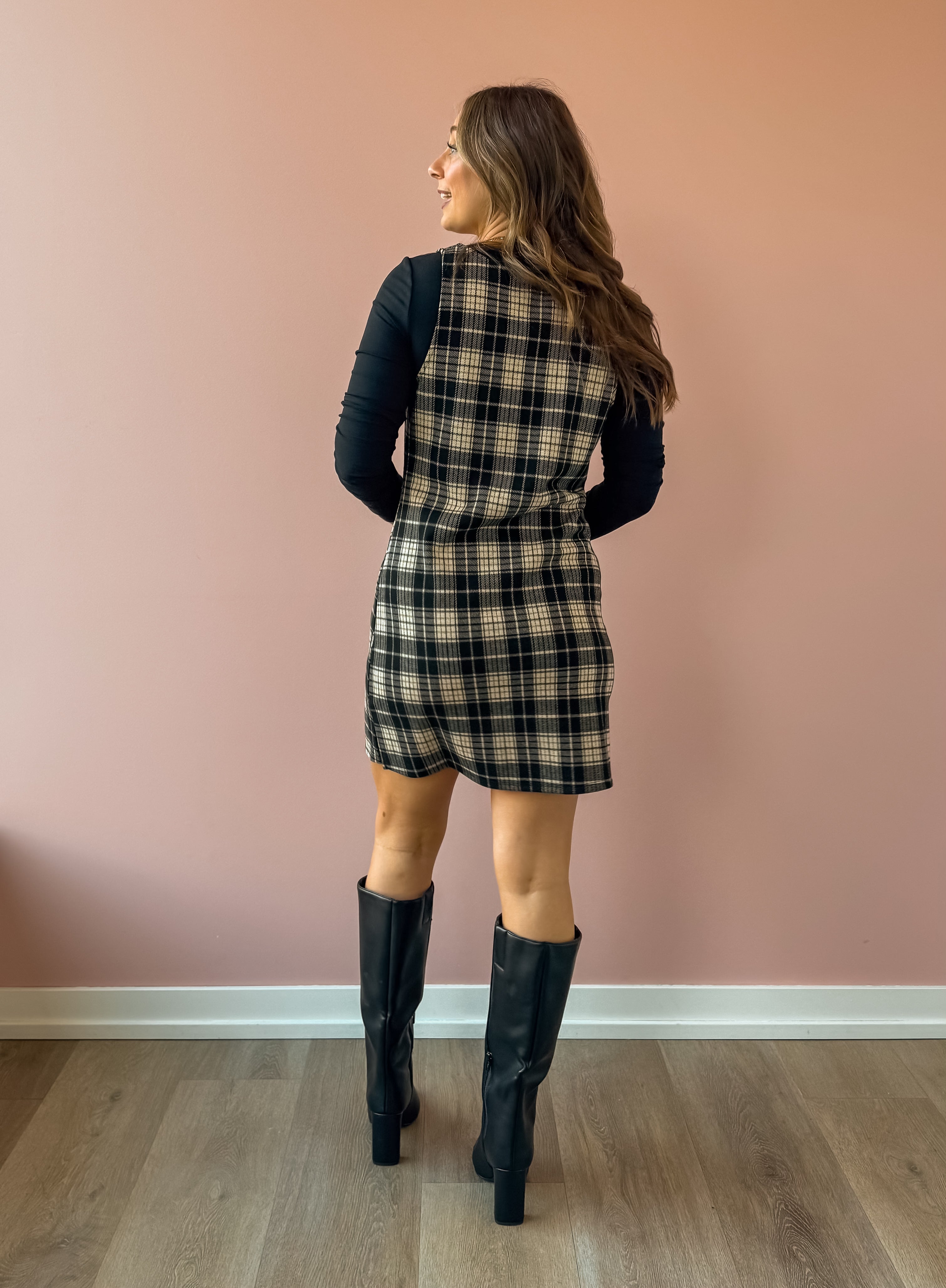 Sadie & Sage Served Up Stretch Plaid Mini Dress in black and tan plaid, back view, layered over a black long sleeve top.