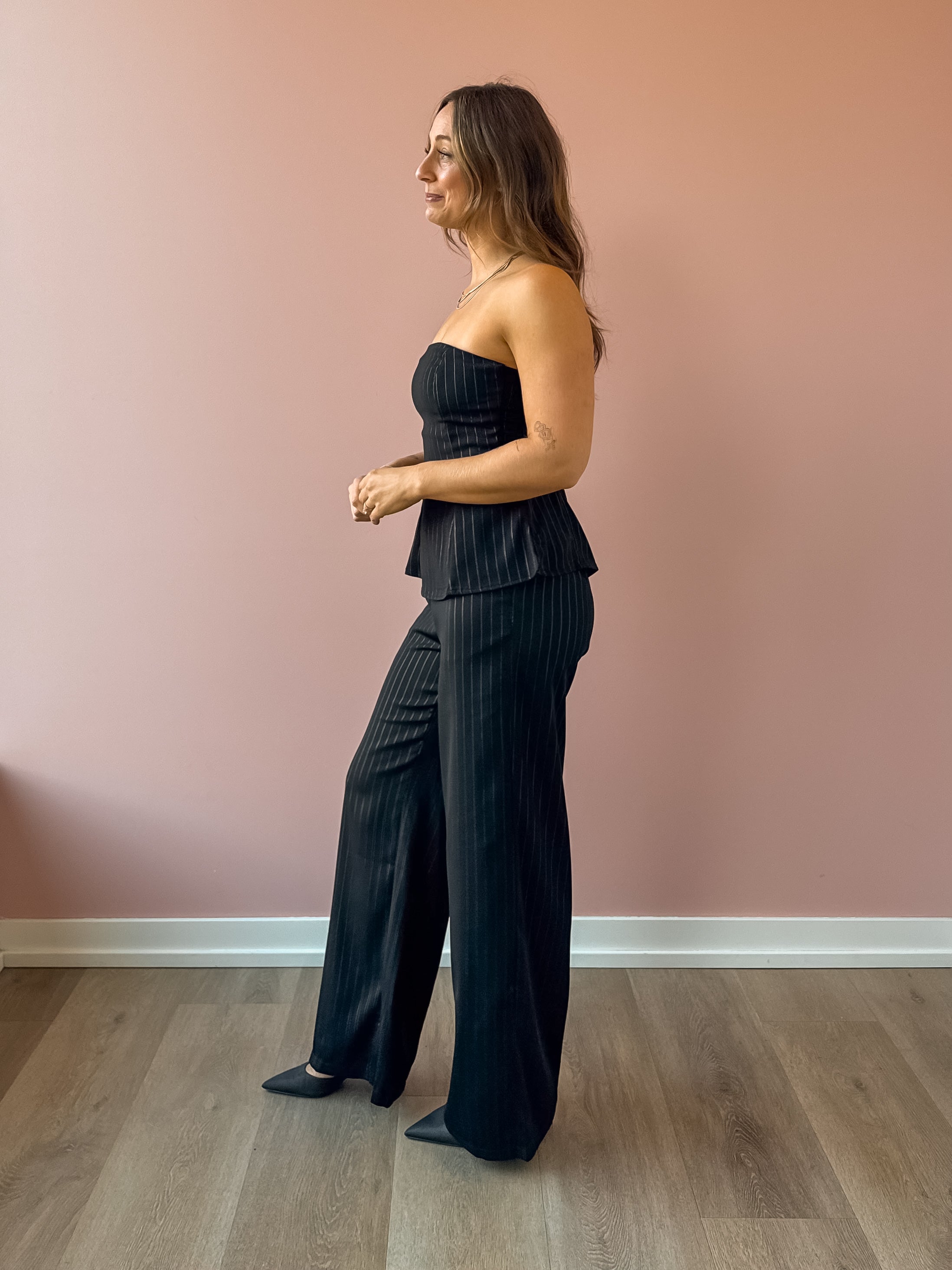 Sadie & Sage Gilded Evening Pinstripe Pants in black with silver pinstripes, side view.